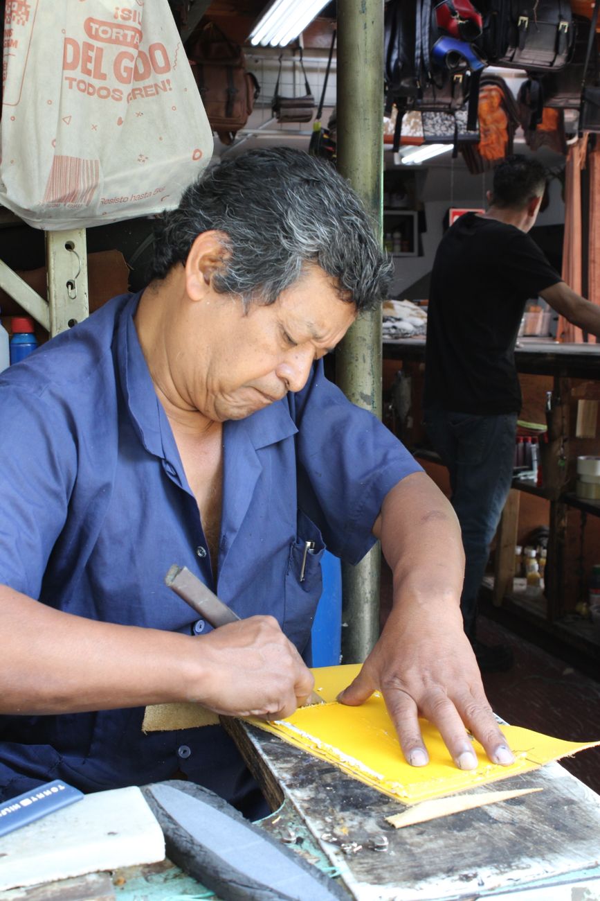 artisan crafting leather in traditional workshop