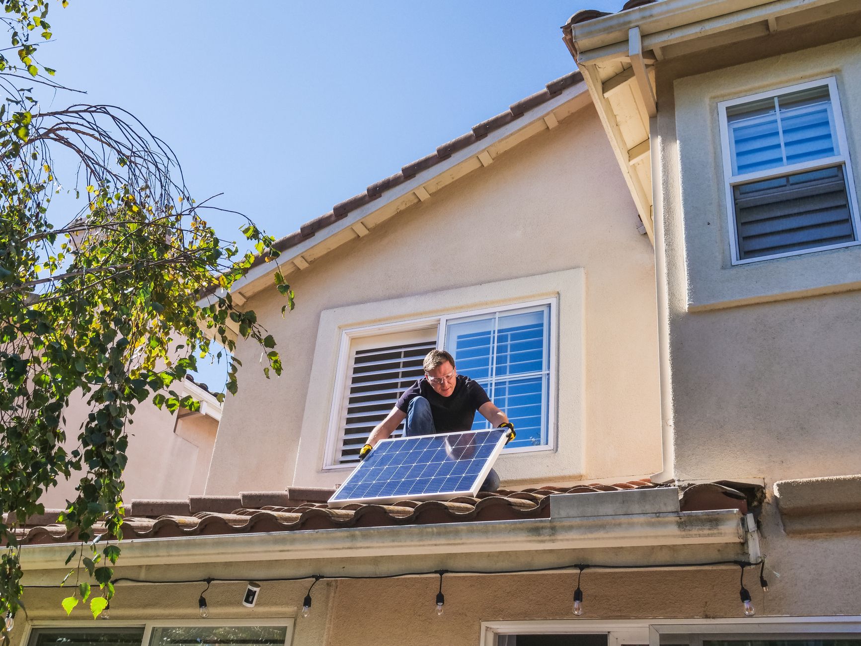 a man inspecting a photovoltaic panel on the roof